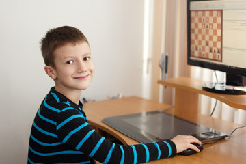 Little boy smile and play online chess