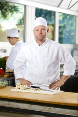 Wall Mural - Confident chef standing in large kitchen