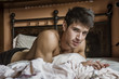 © theartofphoto - Shirtless sexy male model lying alone on his bed