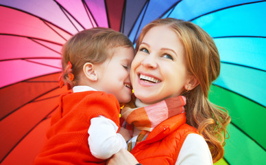 Wall Mural - Happy family mum and child daughter with rainbow colored umbrell