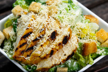 Close Up Caesar Salad With Chicken And Lettuce On Wooden Table