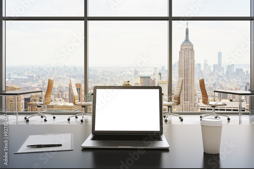 Zdjęcie XXL Miejsce pracy w nowoczesnym biurze panoramicznym w Nowym Jorku. Na białym stole leży laptop z białym ekranem, notatnik i filiżanka kawy. Brązowe skórzane krzesła. Otwarta przestrzeń. Renderowanie 3D. Stonowany obraz.