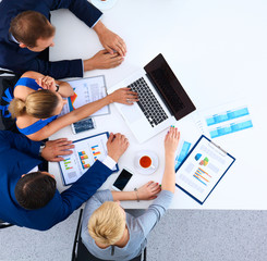 Top view of a team of office workers pointing at a laptop 