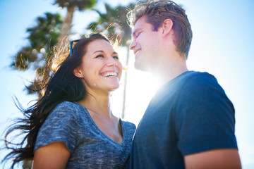 Wall Mural - happy romantic couple outside on sunny day with palm trees