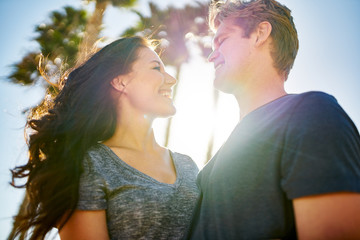 Wall Mural - romantic couple looking lovingly at each other on warm sunny day
