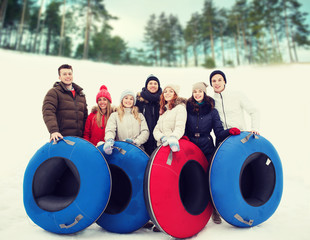 Wall Mural - group of smiling friends with snow tubes