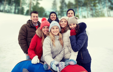 Wall Mural - smiling friends with snow tubes and selfie stick