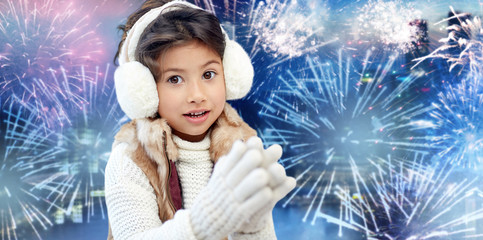 Wall Mural - happy little girl wearing earmuffs over firework