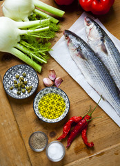 raw fresh fish with vegetable ingredients on a wooden texture ta