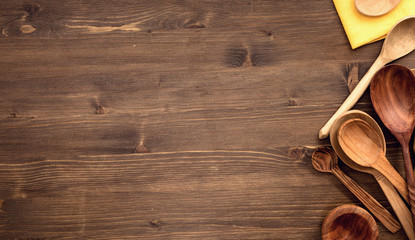 Various wooden spoons at right of wooden table background