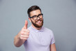 Smiling man in glasses showing thumb up