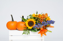Beautiful Colourfull Bouquet Of Fall Flowers With Two Orange Pumpkins On A White Crate