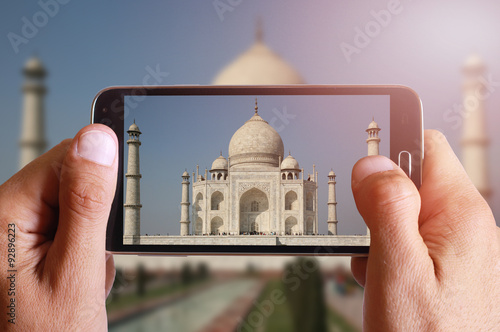 Male hand taking photo of Taj Mahal with cell, mobile phone Canvas Print