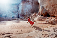 Woman In Red Waving Dress With Flying Fabric Runs On The