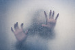 Halloween female hand behind transparent glass background as sil