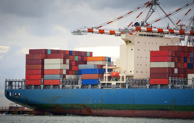 Wall Mural - Cargo ship loaded in the shipping container terminal, Cargo container ship for shipping concept in sunset