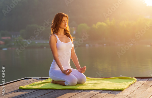 Fotografia Woman Yoga - relax on the pier at the lake