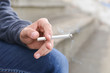 man holding cigarette in his hand closeup outdoor. Cropped shot