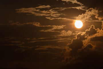 Wall Mural - orange sky with sun and black clouds