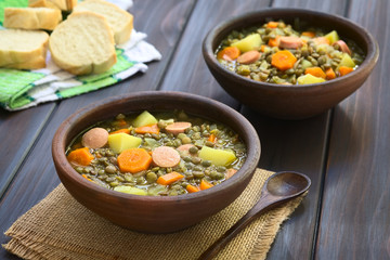 Canvas Print - Lentil soup made with potato, carrot, onion and sausage slices, photographed 
with natural light (Selective Focus, Focus on the middle of the first soup)
