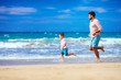 © Olesia Bilkei - happy excited father and son running on summer beach, enjoy life