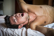 © theartofphoto - Young Sleepy Man, Lying in Bed Yawning