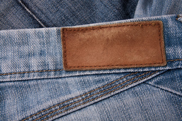 Sticker - fashionable clothes. pile of jeans on a wooden background