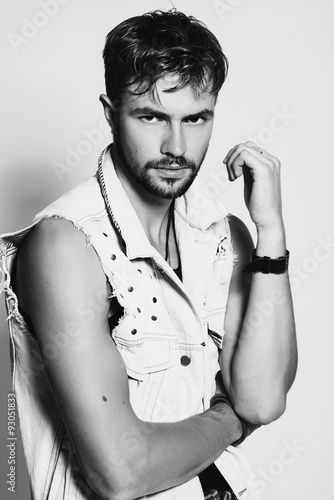 Fototapeta na wymiar Black and white portrait of a stylish young man in the studio