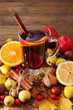 Mulled wine with spices and autumn decor on wooden table. Close up