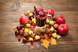 Mulled wine with spices and autumn decor on wooden table