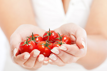 Wall Mural - Young woman holding cherry tomatos