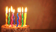 Birthday Chocolate Cake With Burning Multicolored Candles On Brown Background