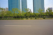 © Aania - Empty road surface with modern city buildings background