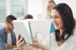 © WavebreakmediaMicro - Smiling woman with headphones using digital tablet