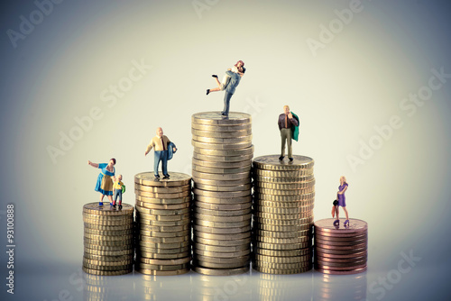 Fotografía Faily budget concept. Miniature family on coins pile.