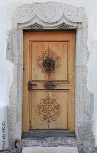 Naklejka na szybę Vintage wood medieval door in rural stone wall house,Switzerland