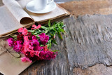 Fototapeta Lawenda - Old book with beautiful flowers and envelopes on wooden table close up