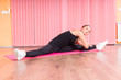 © kolotype - Young Woman Stretching in Splits Pose in Studio