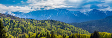 Romania, Predeal. Panorama with the snowy peaks of the Bucegi mountains and the green forests of Predeal,  in springtime, when the nature comes back to life and the snow starts to melt
