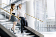 © NDABCREATIVITY - Business colleagues talking on stairs