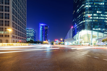 asphalt road near skyscrapers at night