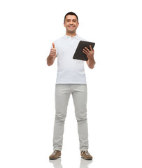 Wall Mural - smiling man with tablet pc showing thumbs up