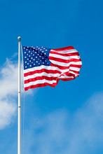 American Flag Waving Against Blue Sky. Copy Space.