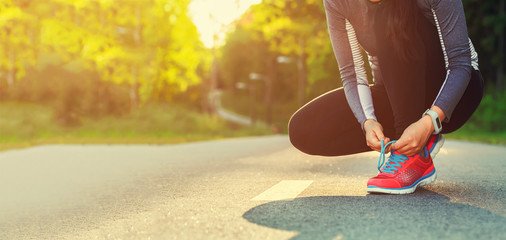 Female runner tying her shoes preparing for a jog