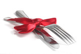 Fototapeta Londyn - Fork and knife with christmas ribbon, isolated on white, shallow