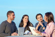 © alexbrylovhk - Mixed group in business meeting Four People Casual Clothing Sitting Around Wooden Desk and Discussing Looking on Paper Work and Listening Arguments