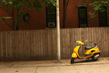 A Court Yard With A  Yellow Vespa