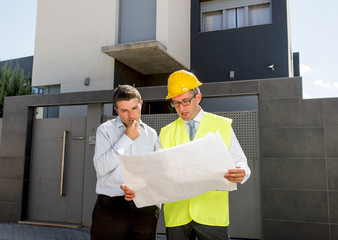 customer and constructor foreman worker talking on new house building blueprints in real state business concept