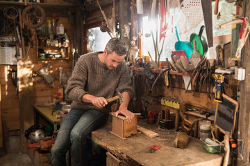 Wall Mural - man with beard wearing wool sweater, working in his workshop