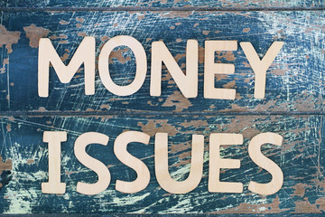 Wall Mural - Money issues written on rustic wooden surface
